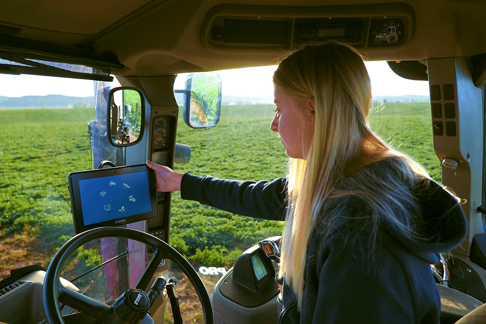 Girl in tractor cab using the GFX-1050 Trimble display