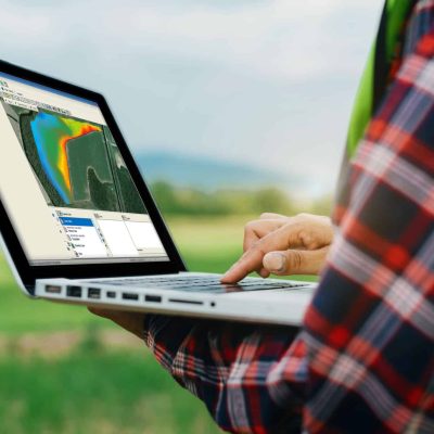 Farmer using laptop checking report of agriculture in farm.